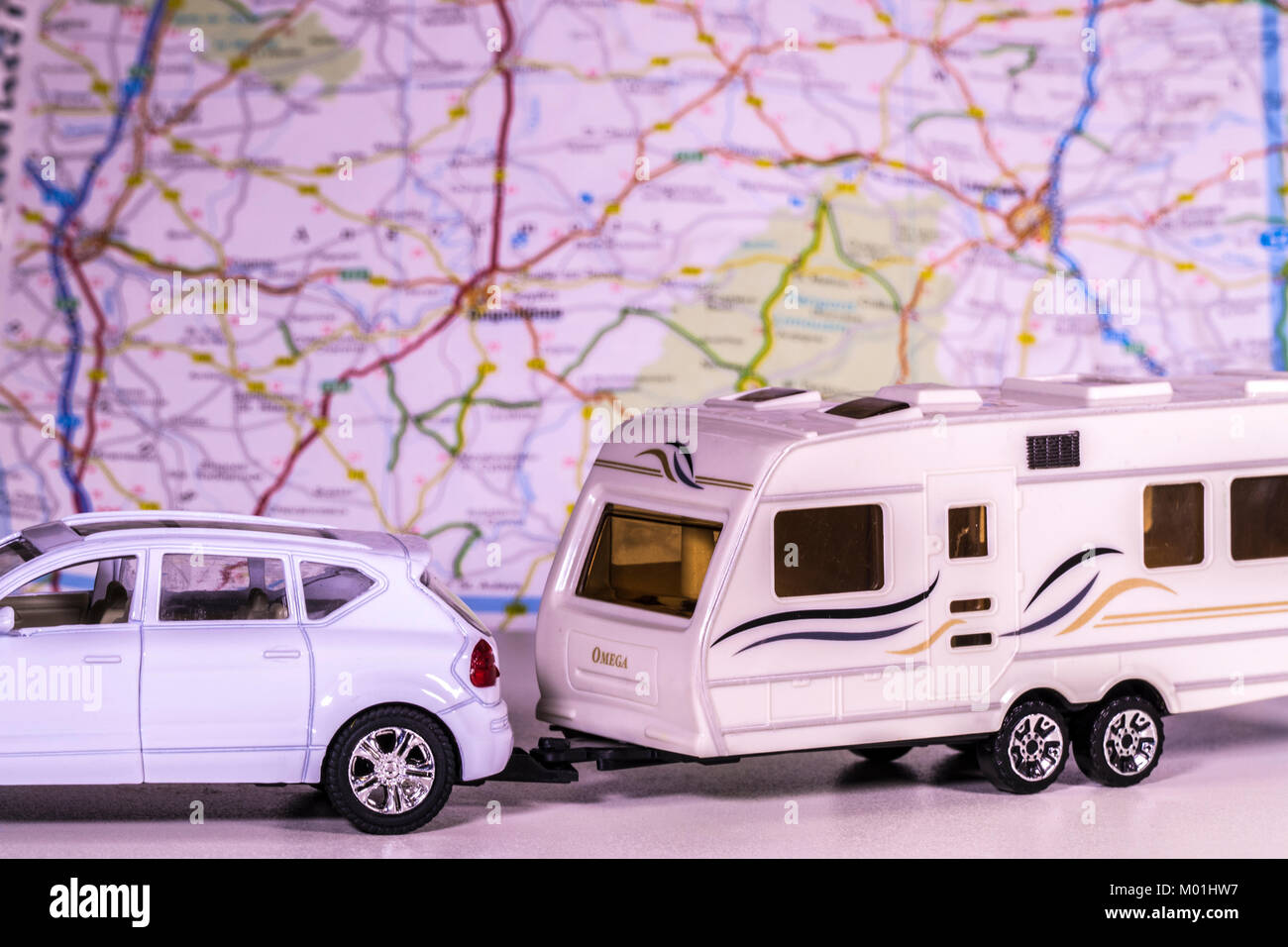 Caravana y modelo de coche con un mapa de desenfoque / atlas en el fondo. Concepto de cualquier aspecto de camping / touring / la libertad del camino abierto, etc. Foto de stock