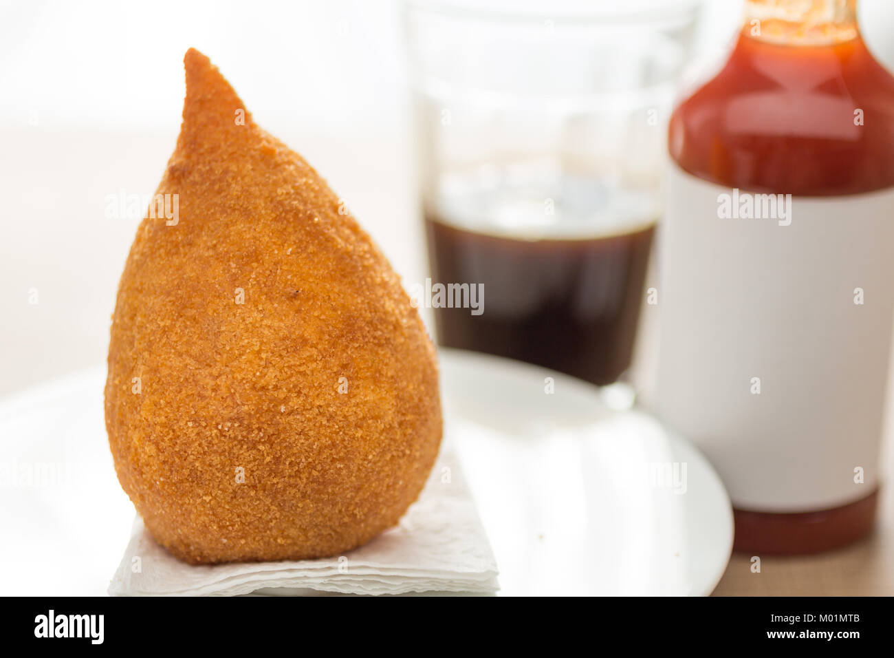 Deep Fried Chicken finger food conocido como Coxinha en Brasil. Los brasileños comen comida rápida como alternativa o en partes. Snack, salsa de pimienta y café bar. Foto de stock