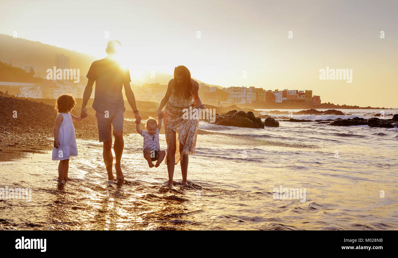 Alegre familia divirtiéndose en la playa, verano retrato Foto de stock