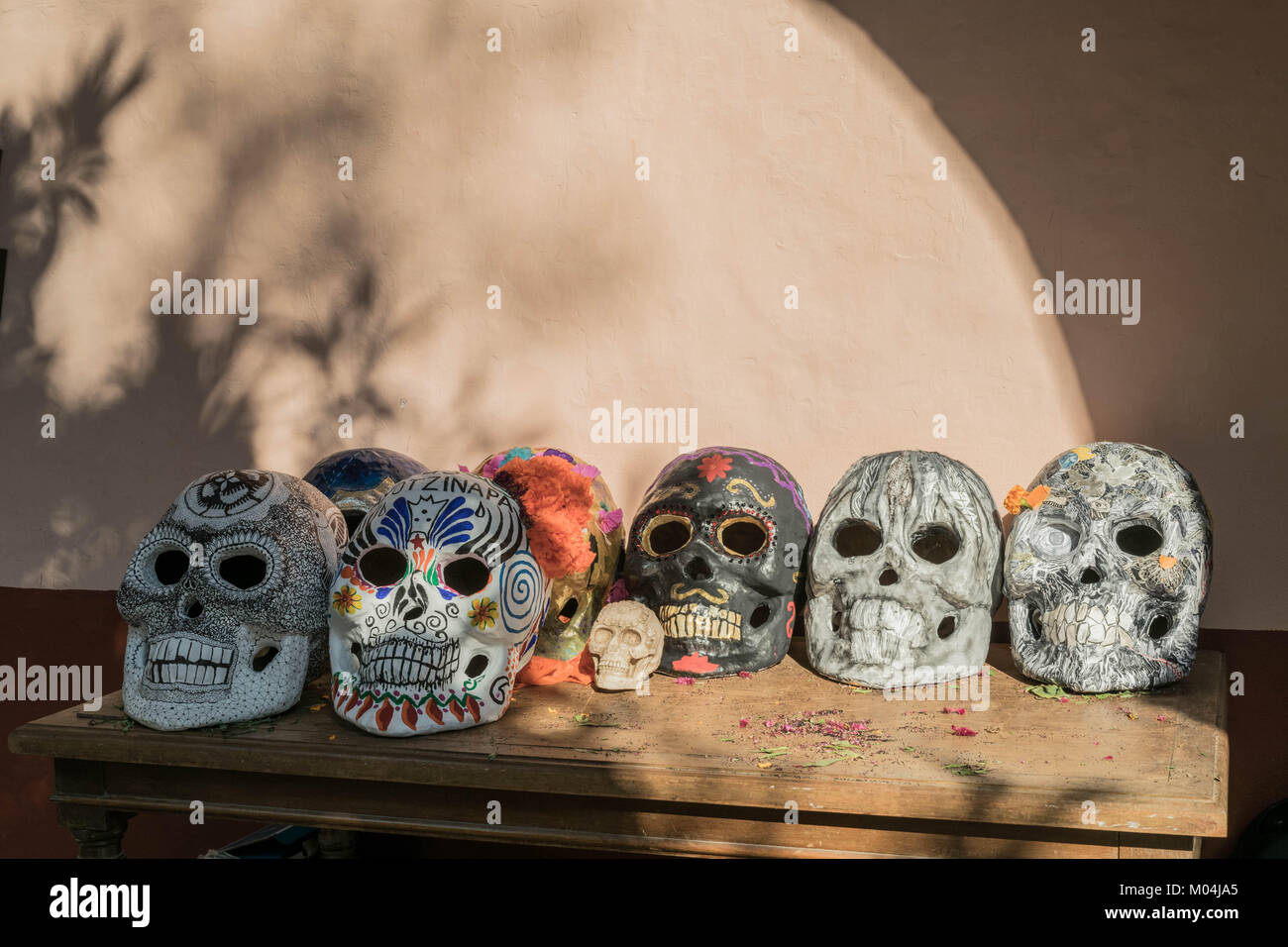 Para editar Violín Fácil de suceder Siete grandes y un poco pintados de calaveras, sobre una mesa de madera  grande, con sombras en la pared, para la celebración del Día de los  muertos, en México Fotografía de stock -