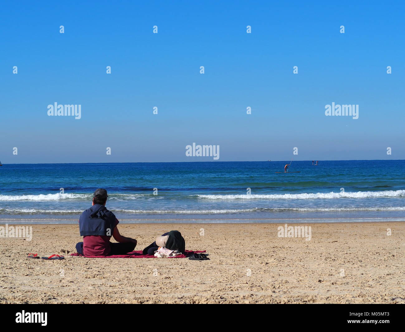 Recreación de vacaciones - pareja está tumbado y sentado junto al sol en una playa de arena Foto de stock