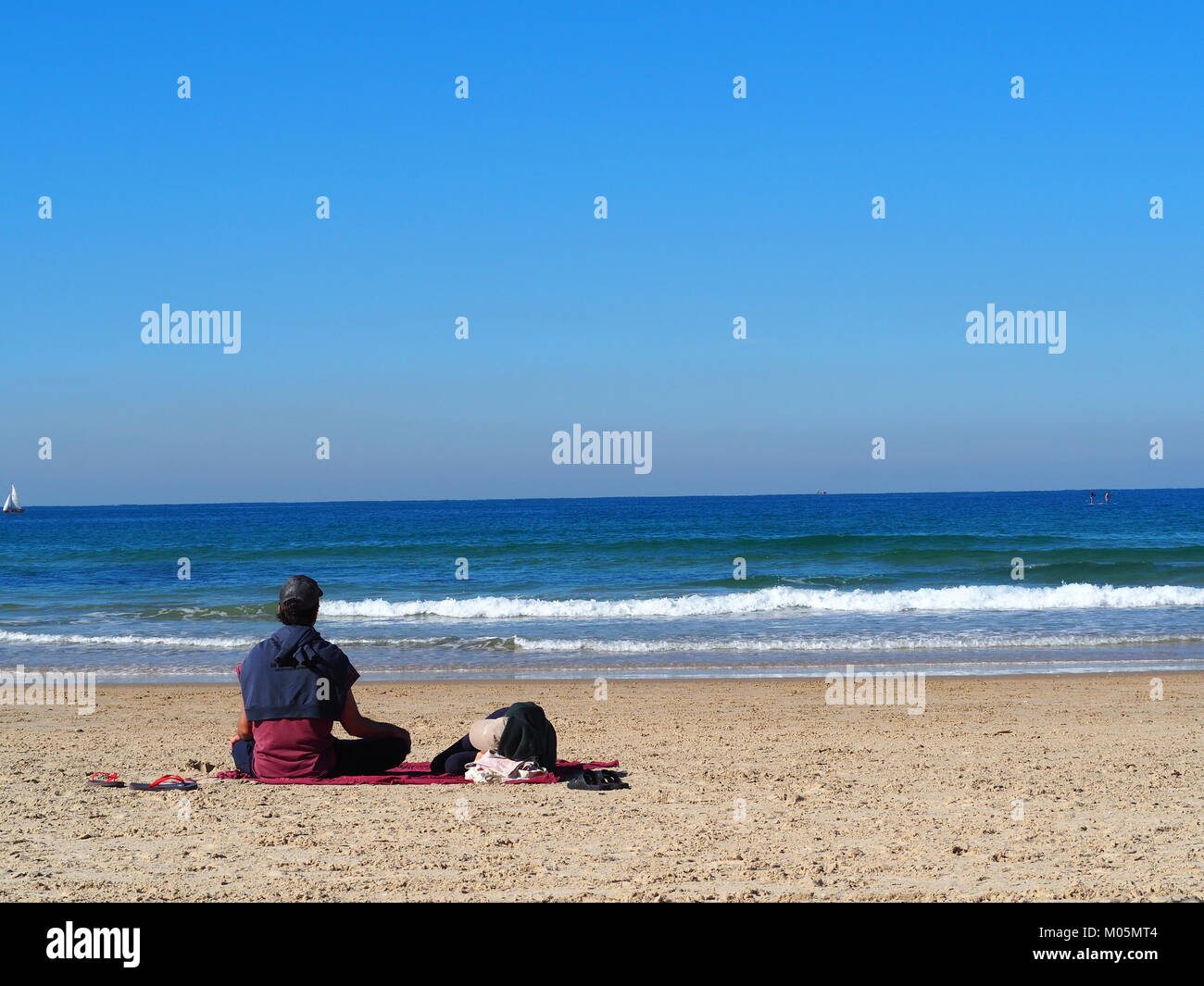 Recreación de vacaciones - pareja está tumbado y sentado junto al sol en una playa de arena Foto de stock