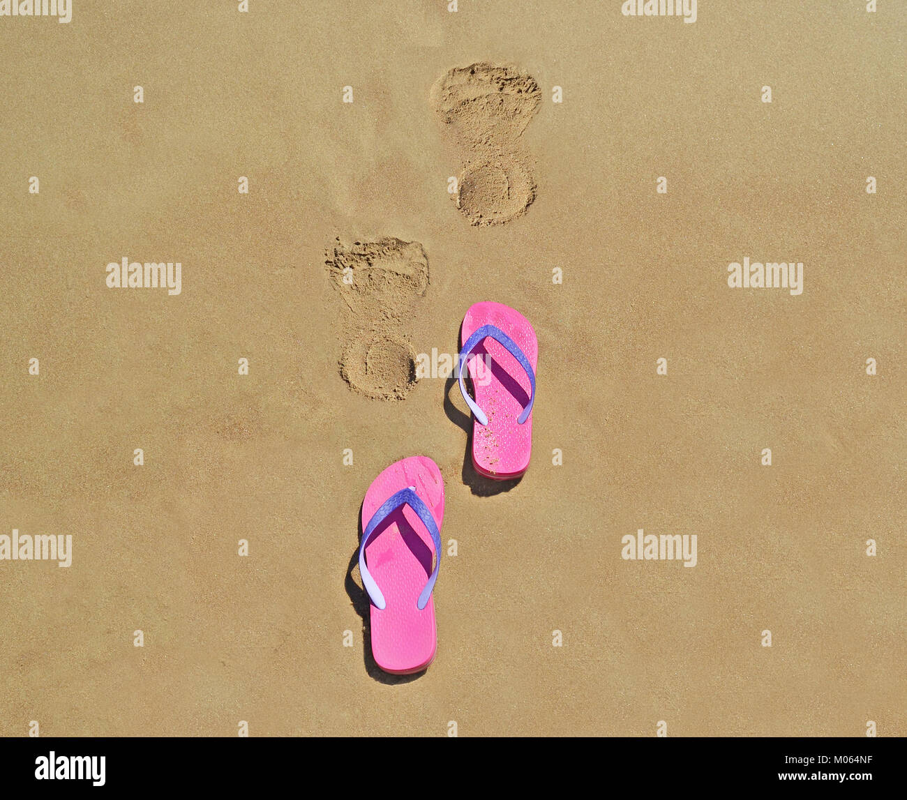 Chanclas de verano en la playa con huellas en la arena - Icono de  vacaciones de verano Fotografía de stock - Alamy