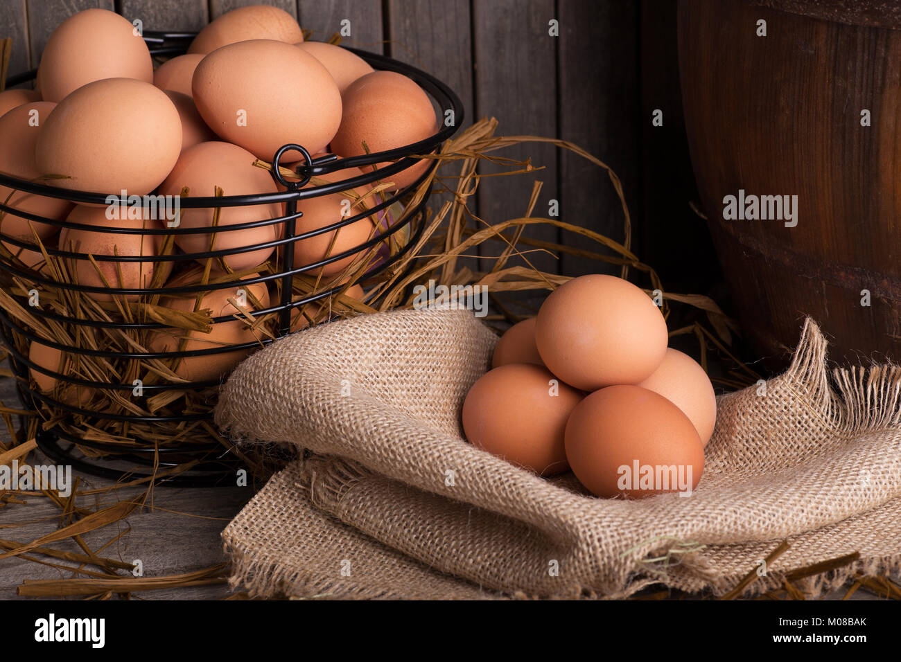 Brown pollo huevos en una canasta y sobre una tela de arpillera Foto de stock