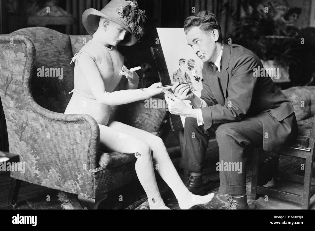 James Montgomery Flagg chica posa con un maniquí que él usa para pintar Foto de stock