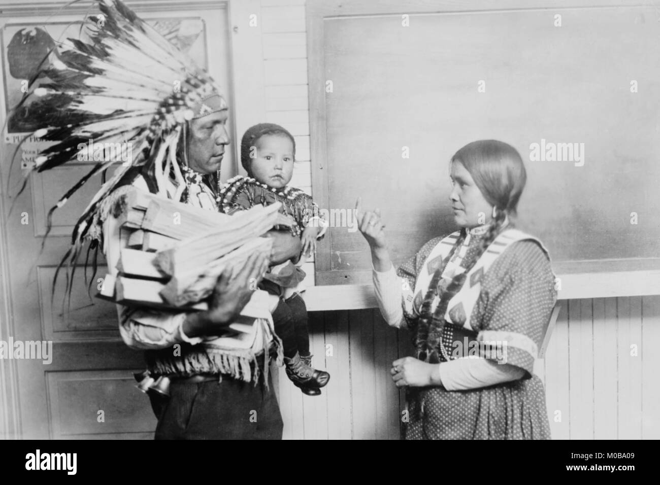Jefe Lobo peces túnica en vestimentas nativas y War Bonnet, su hijo y su esposa Foto de stock