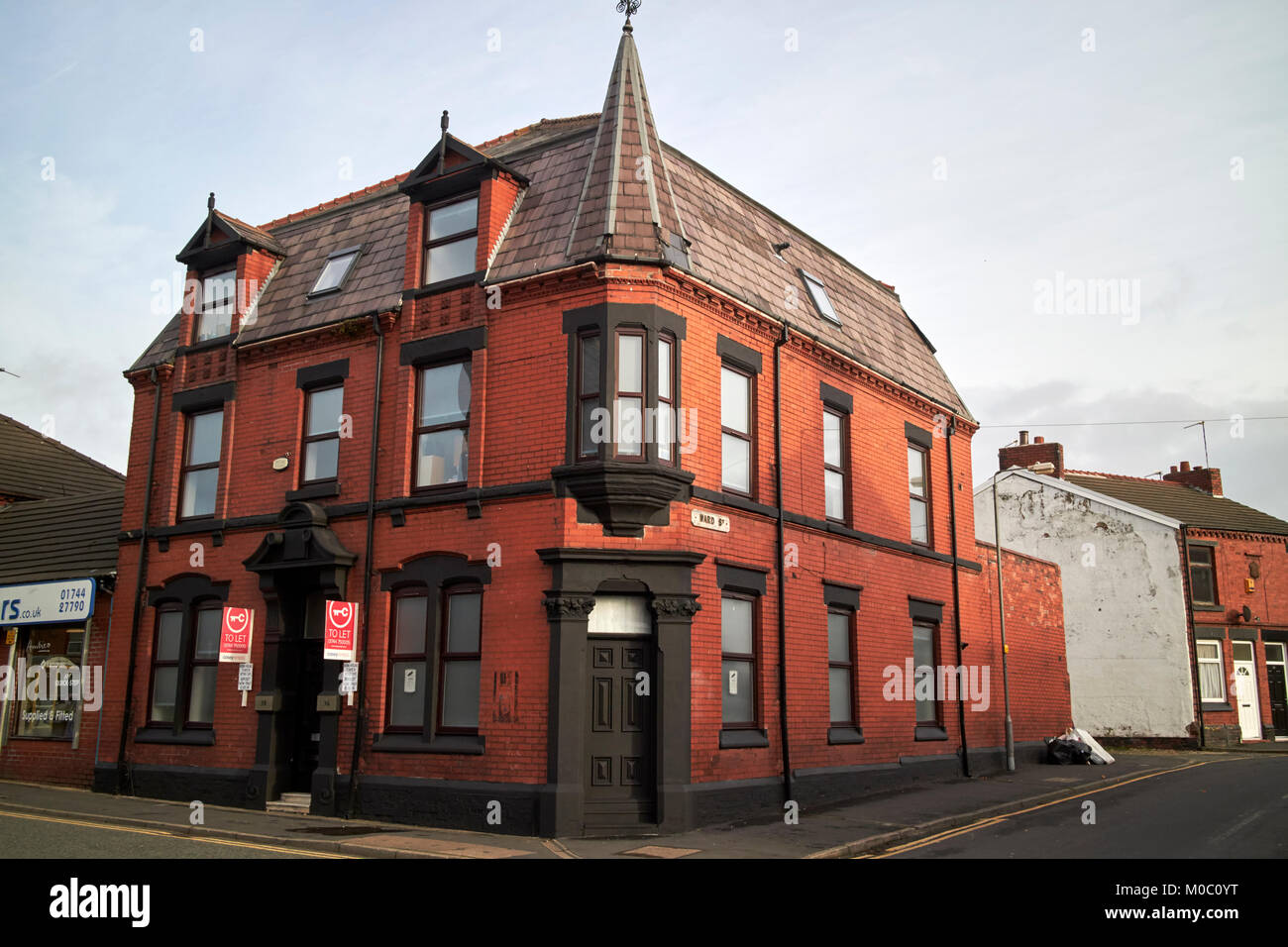 Antiguo edificio victoriano de ladrillo rojo con la arquitectura ornamental en el cruce de la calle Ward y 36 north road St Helens merseyside uk Foto de stock