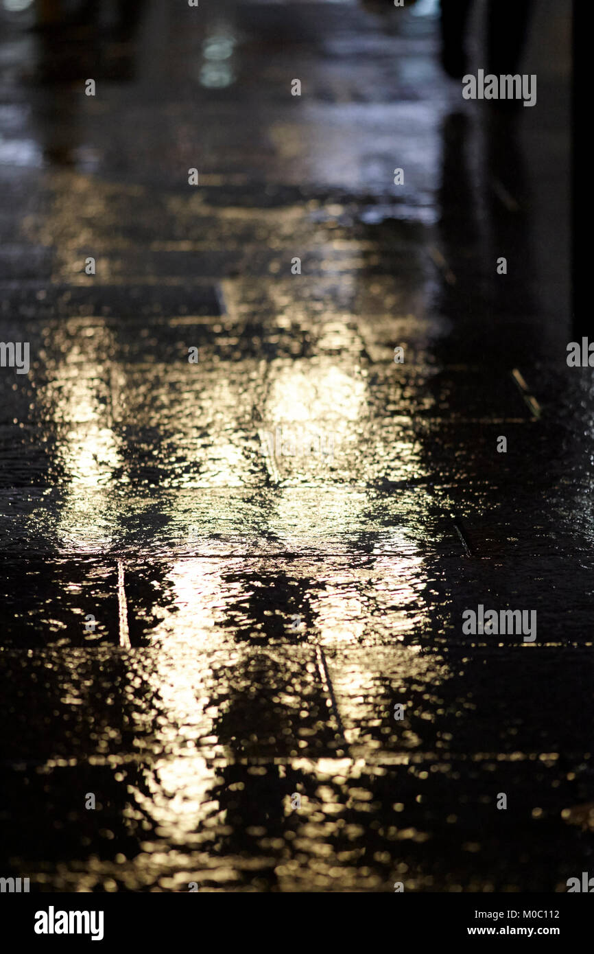La luz reflejándose en el pavimento mojado en zona peatonal urbanas Belfast, Irlanda del Norte, reino unido Foto de stock