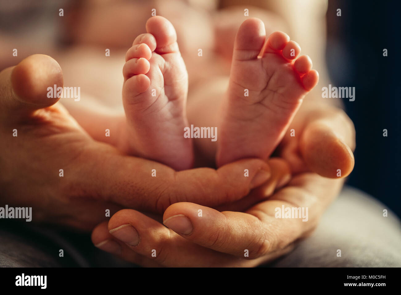 Las piernas del bebé recién nacido en madres adorable mano con foco suave de babie's Foot Foto de stock