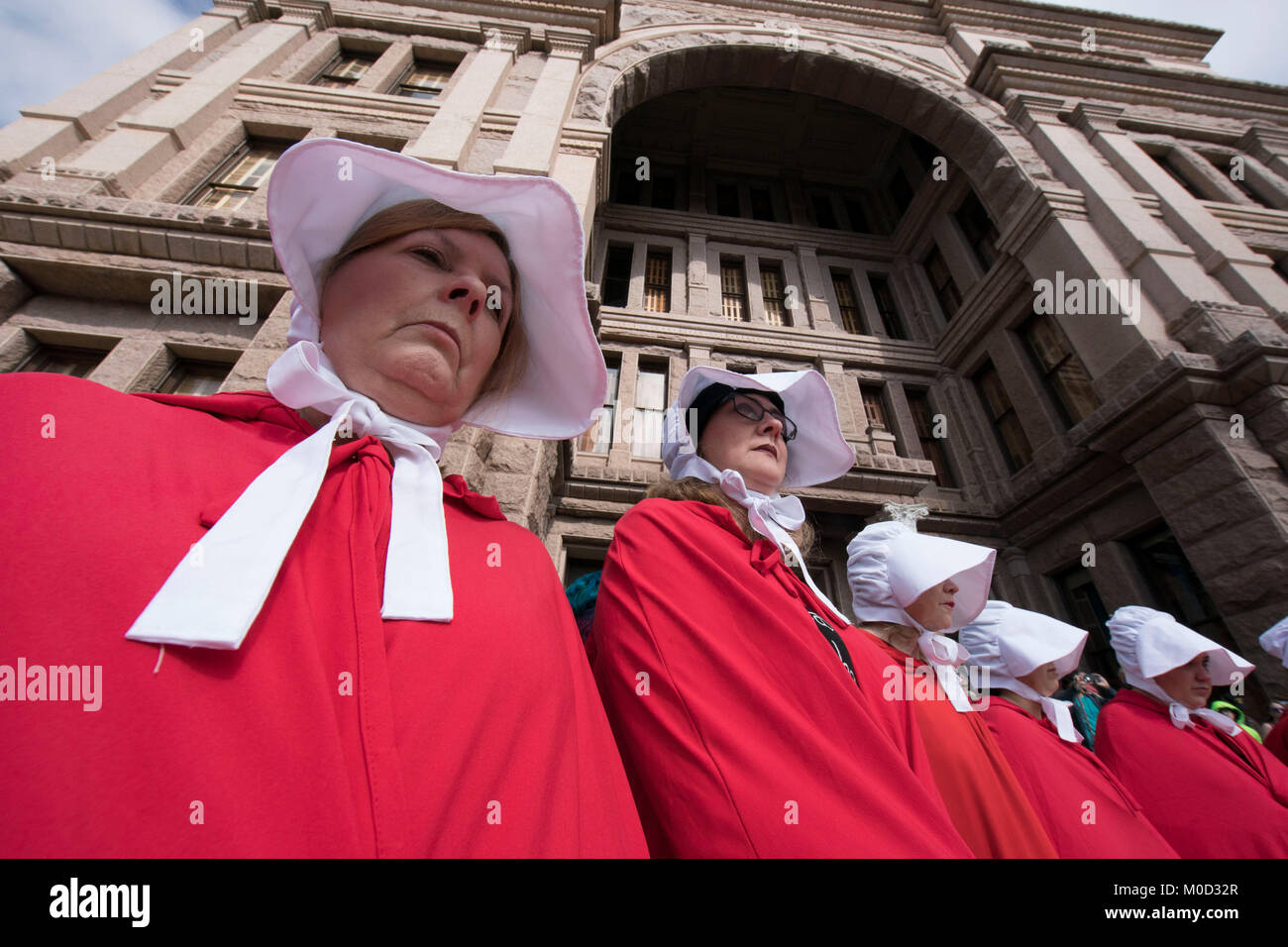 Mujeres vestidas como personajes del libro de Margaret Atwood "Handmaid's Tale' participan en un mitin en el Capitolio de Texas, en Austin para conmemorar el primer aniversario de la marcha de mujeres del Washington y políticas que se oponen a la promulgada durante la Presidencia de Donald Trump en su primer año en el cargo. Foto de stock