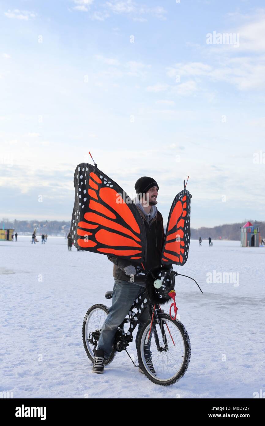 Un hombre en una bicicleta con alas de mariposas, en el arte Shanty  proyectos sobre el lago congelado Harriet en Minneapolis, MN, USA  Fotografía de stock - Alamy