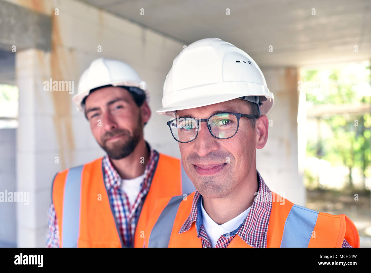 El trabajo en equipo en el sitio de construcción - Site manager y arquitecto en el sitio durante la construcción de una casa Foto de stock