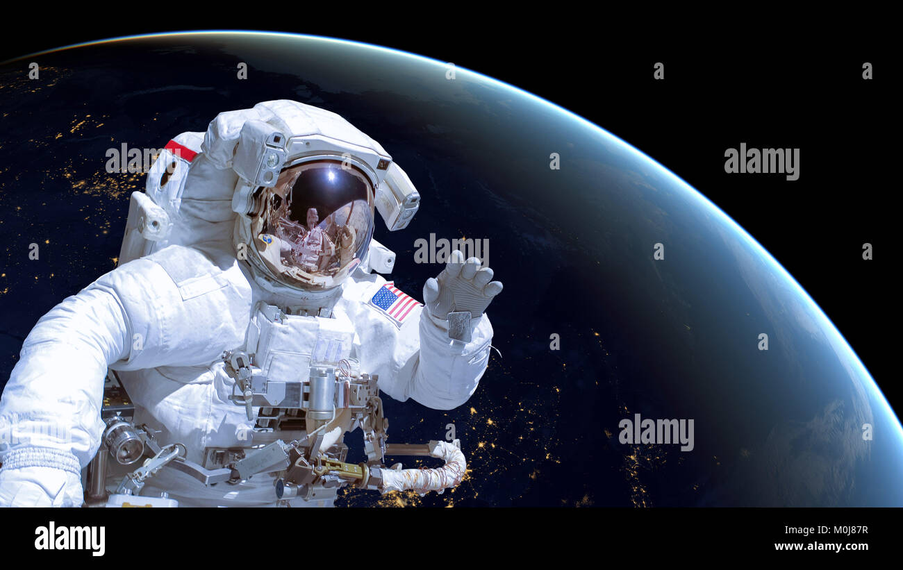 Primer plano de un astronauta en el espacio exterior, la tierra por la noche en el fondo. Los elementos de esta imagen están amuebladas por la NASA. Foto de stock