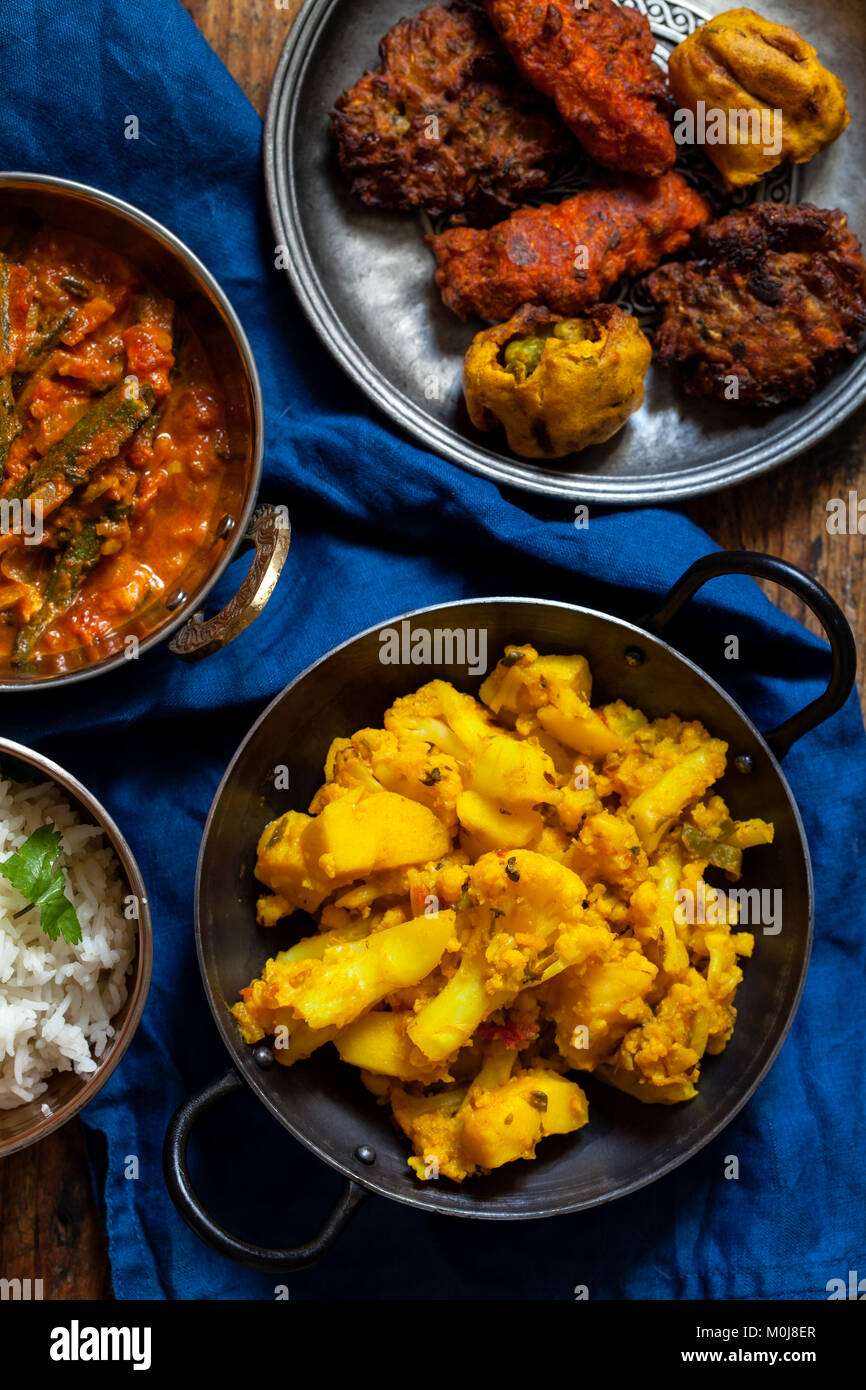 Comida india con okra Aloo Gobi, curry, arroz y pakoras Foto de stock