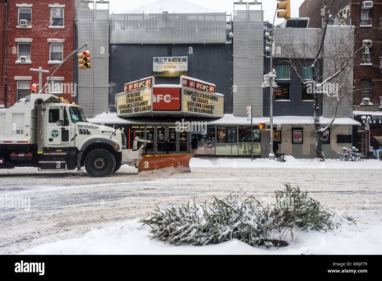 Nueva York, NY el 4 de enero de 2018 - Un camión del Departamento de Saneamiento despeja la nieve sobre la Sexta Avenida durante la tormenta de nieve después de Navidades. Foto de stock