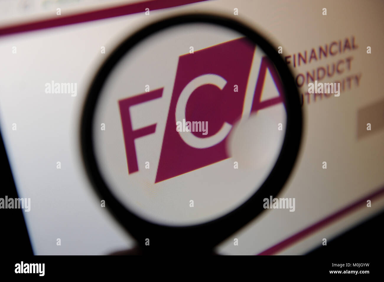La conducta de la autoridad financiera logotipo del sitio web vistos a través de una lupa Foto de stock