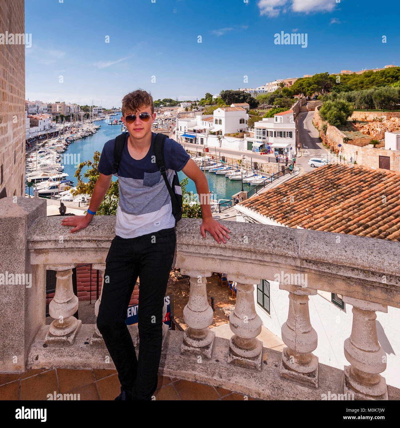Un adolescente en el puerto de Ciutadella de Menorca, Menorca, Islas Baleares, España Foto de stock