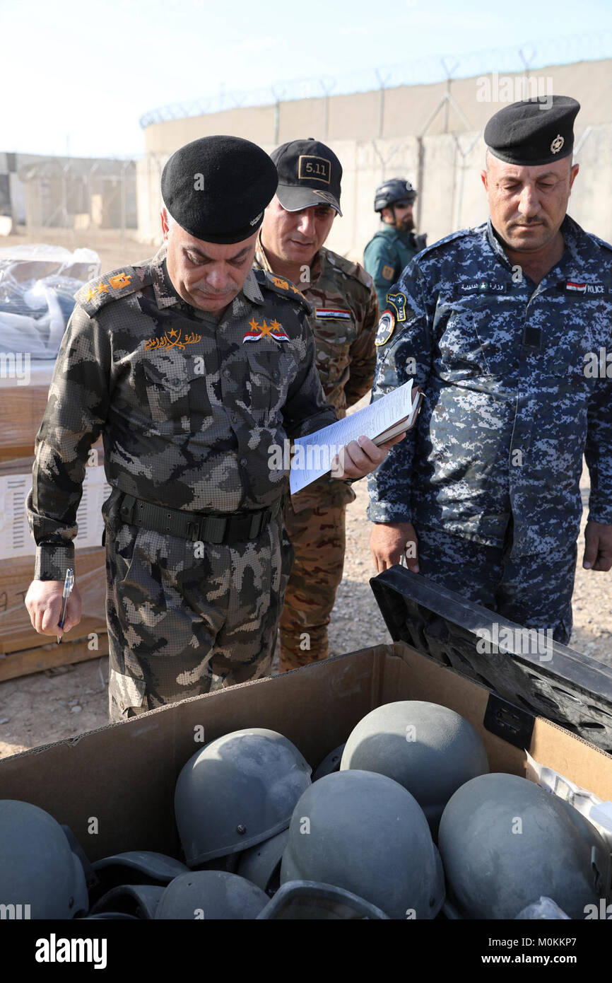 Miembros del ejército y la policía de Iraq mira cascos balísticos en un  contenedor durante la venta de ropa orgánica y equipamiento individual para  el ejército y la policía iraquí en la