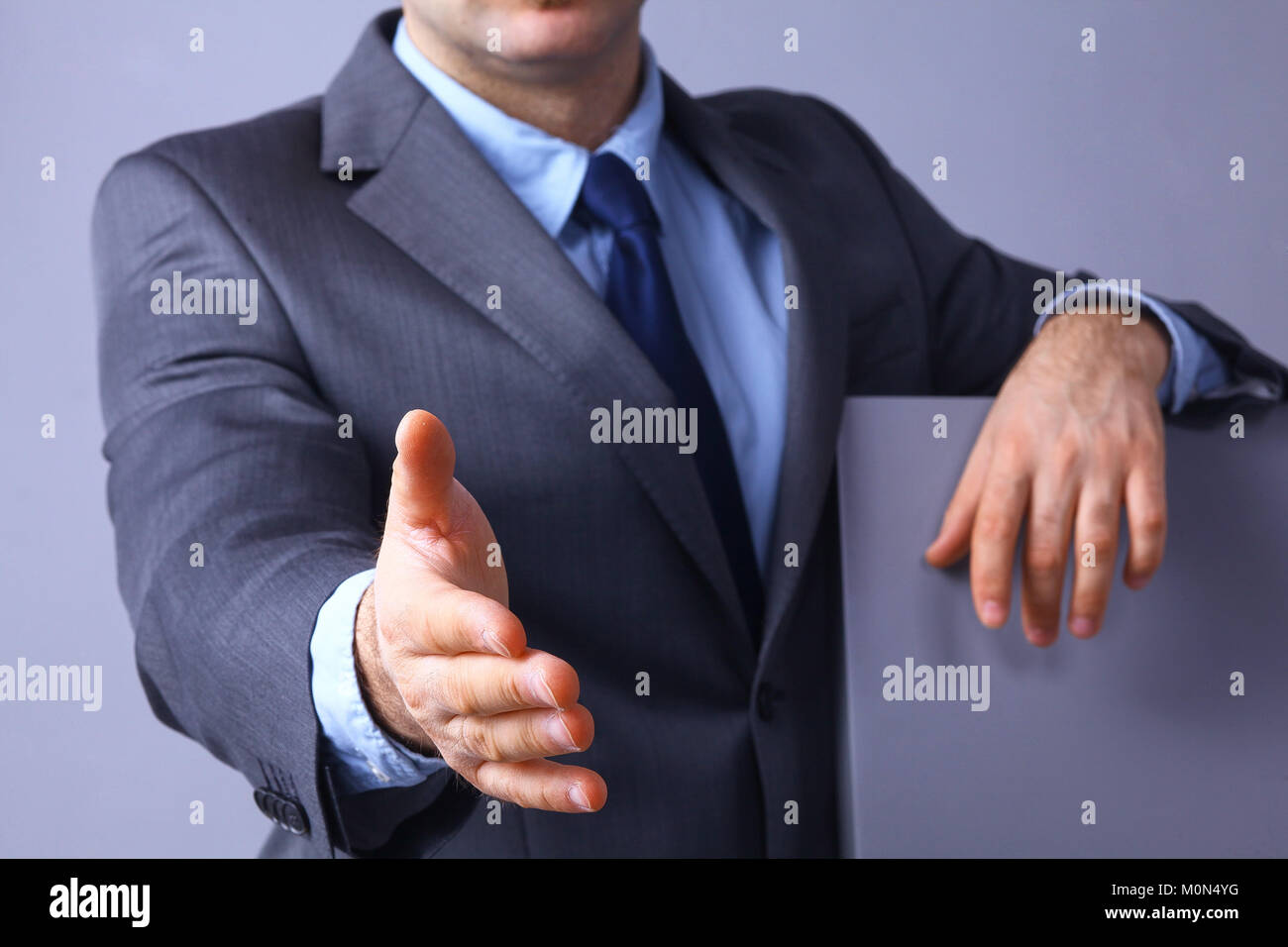 Hombre vistiendo un traje ofreciendo a estrecharse las manos Foto de stock