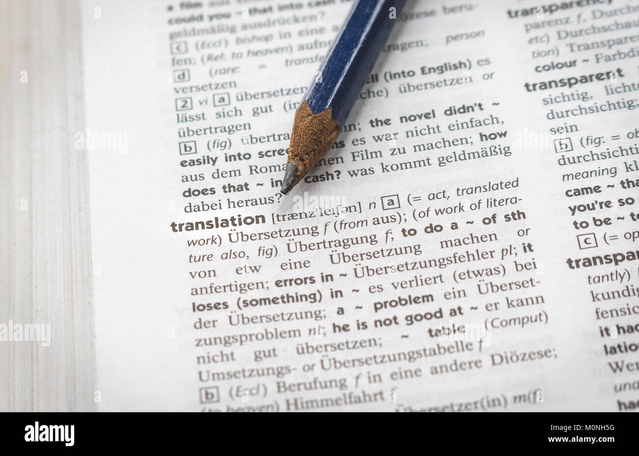 Concepto de traducción, lápiz apuntando a la palabra 'traducción' en un  diccionario Inglés Alemán Fotografía de stock - Alamy