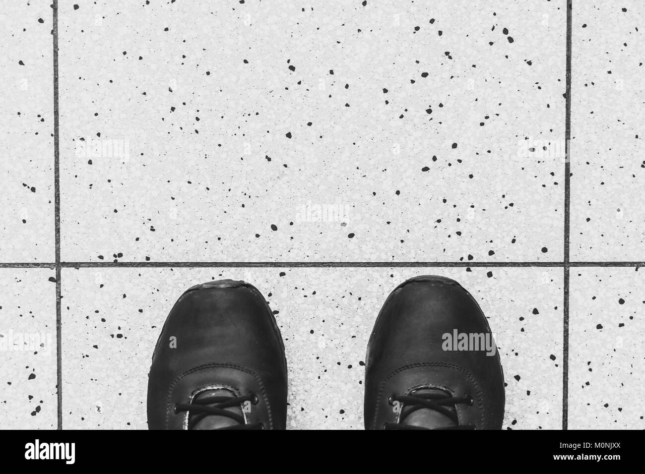 Botas negras las mujeres están de pie en el piso de mosaico Fotografía de  stock - Alamy