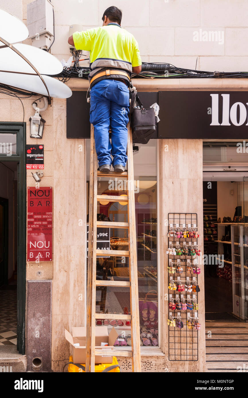 Un hombre trabajando con una escalera en Mahón, Menorca, Islas Baleares, España Foto de stock