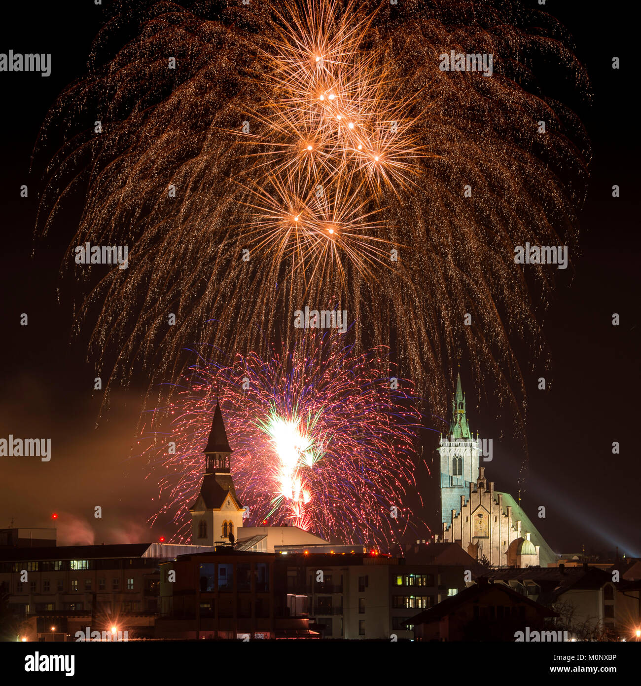 Fuegos artificiales sobre Schwaz en la víspera de Año Nuevo con Spitalskirche y la iglesia parroquial,Schwaz, Tirol, Austria Foto de stock