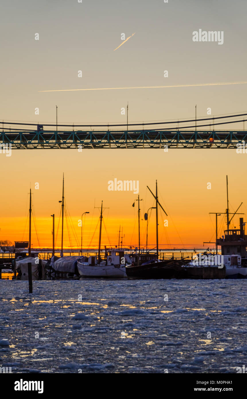 Gotemburgo - atardecer en embarcaciones a vela y pesca en río Gota congelada en Puente Hisingsleden durante el invierno Foto de stock
