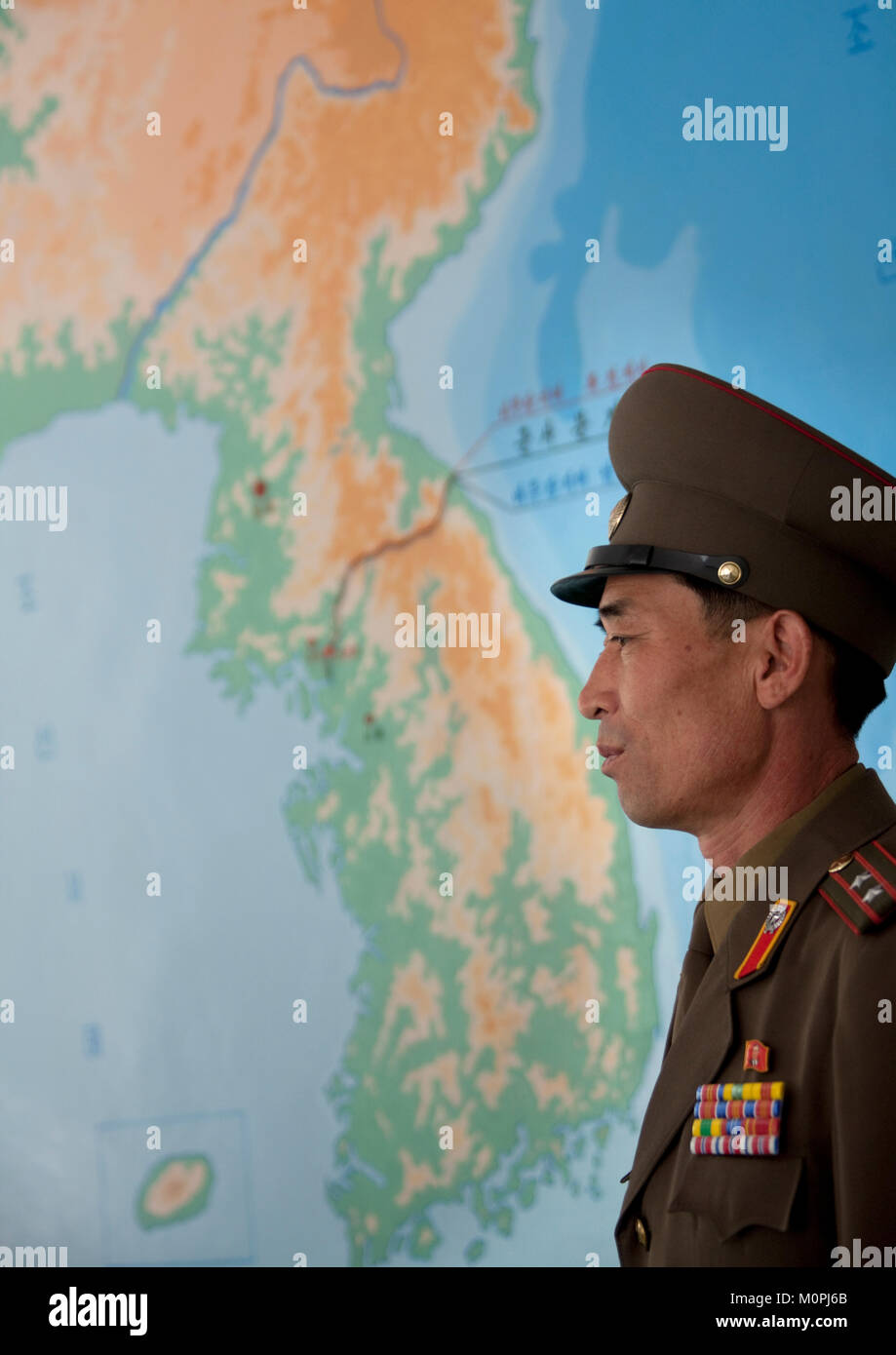 Oficial de Corea del Norte en frente de un mapa de Corea en la zona