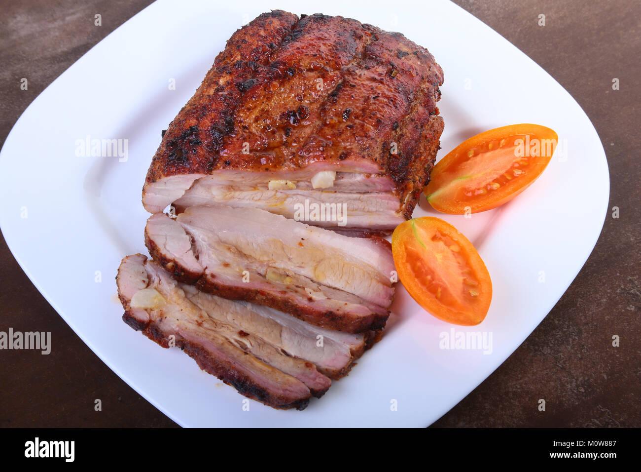 Chuletas de Cerdo Asadas con tomate y salsa de tomate en el plato. Foto de stock