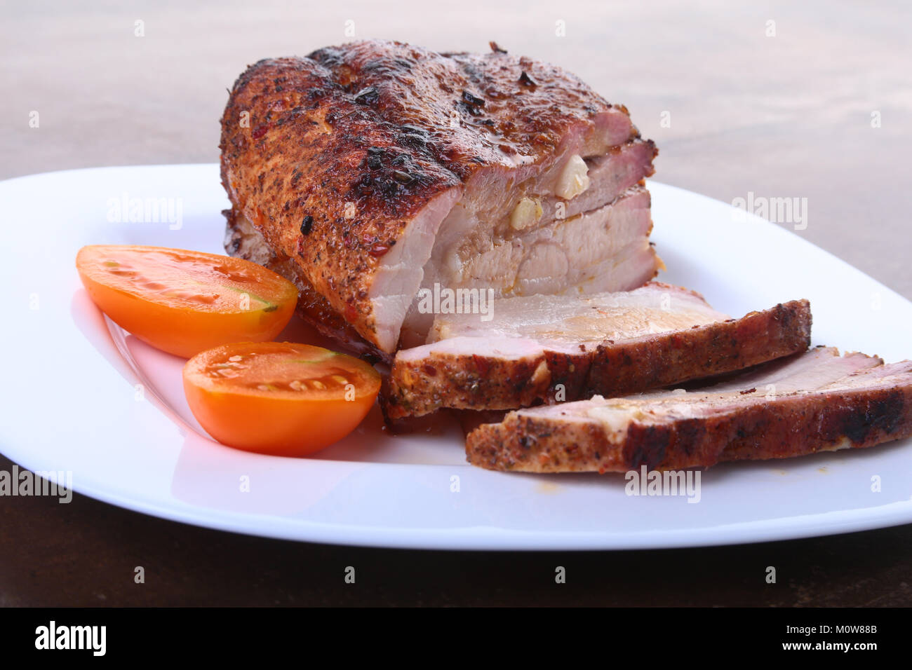 Chuletas de Cerdo Asadas con tomate y salsa de tomate en el plato. Foto de stock