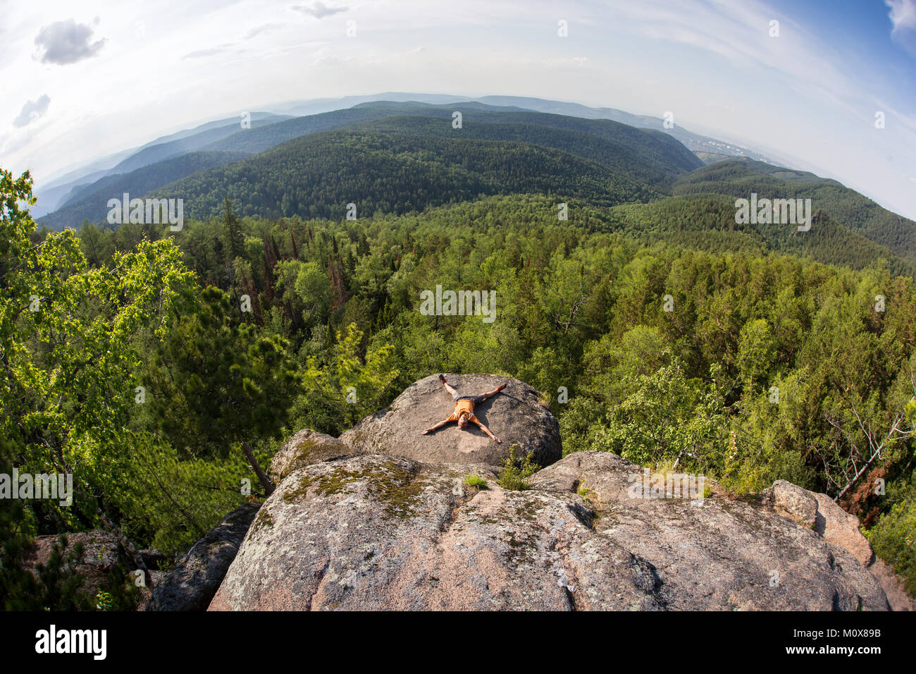Hombre meditando sobre una roca Foto de stock
