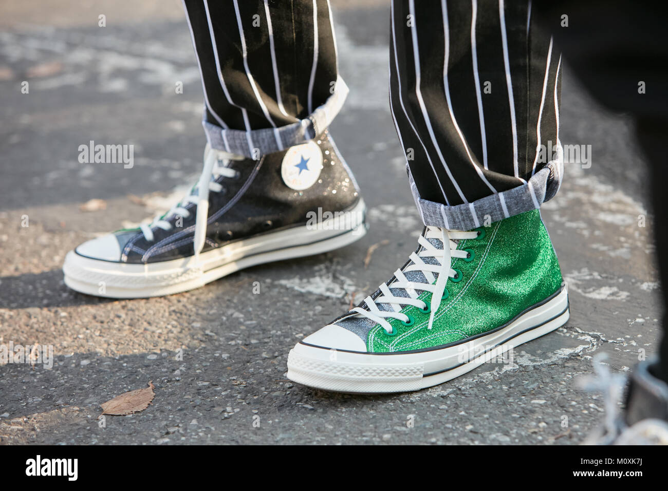 Milán - 13 de enero: el hombre con green Converse All Stars glitter  zapatillas y pantalones a rayas en blanco y negro antes de Diesel Black  Gold Fashion Show, Mil Fotografía de