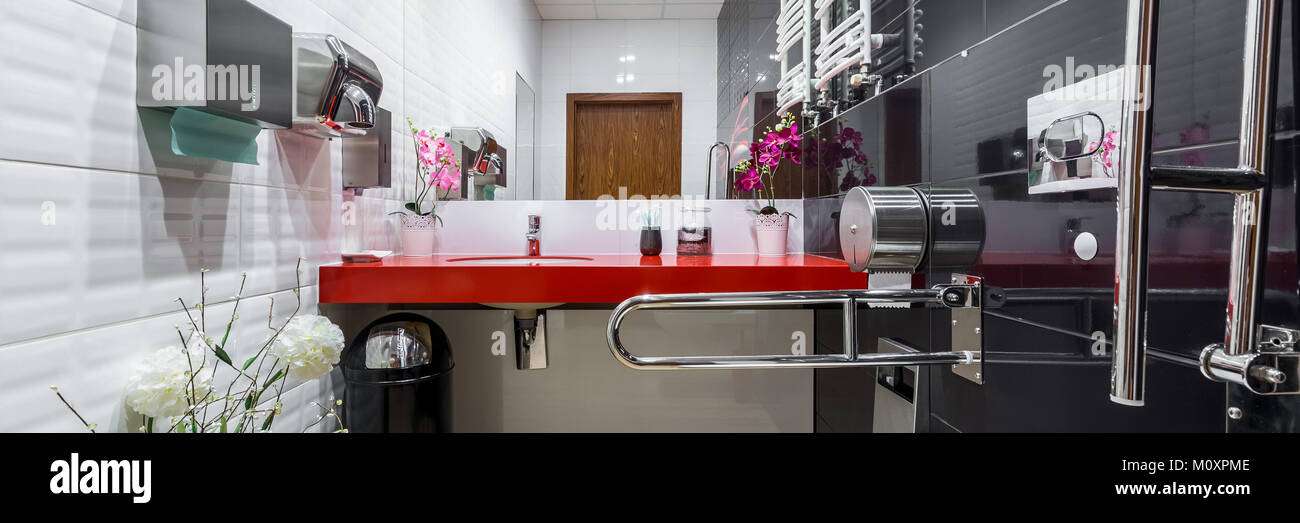 Vista panorámica de blanco y negro para discapacitados Baño con lavabo encimera rojo Foto de stock