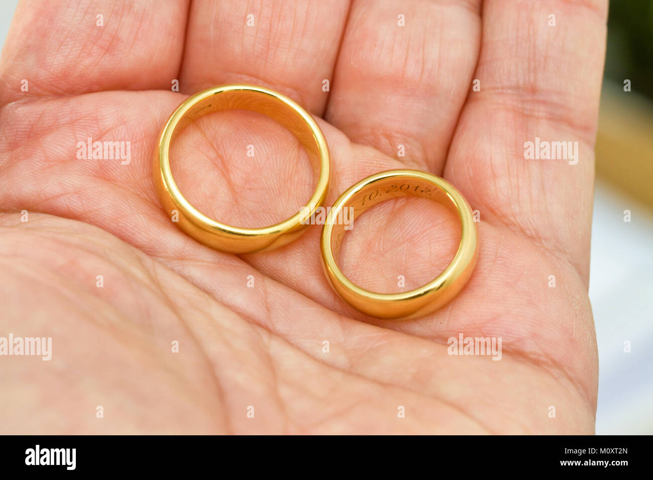 Dos anillos de boda en la mano Foto de stock