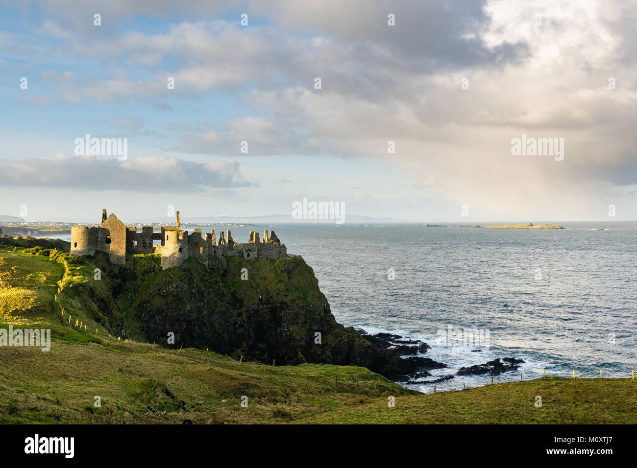 Castillo de Dunluce en la costa de Antrim, en Irlanda del Norte. Las ruinas del castillo de sitio en la cima de un acantilado con vistas al océano Foto de stock