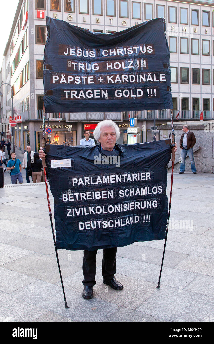 Alemania, Colonia, manifestante en frente de la catedral (traducción: Jesús lleva la madera. papas y cardenales se viste de oro y los parlamentarios desvergonzados Foto de stock