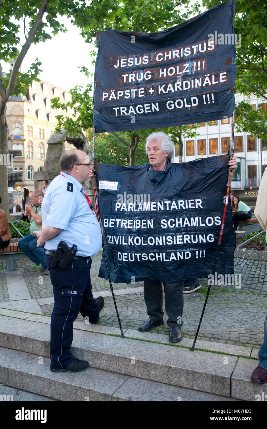 Alemania, Colonia, manifestante en frente de la catedral (traducción: Jesús lleva la madera. papas y cardenales se viste de oro y los parlamentarios desvergonzados Foto de stock