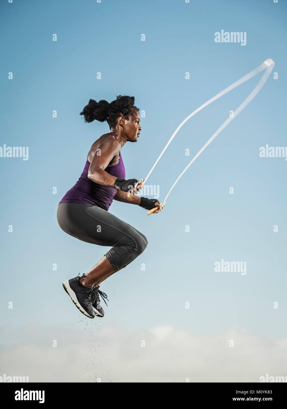 Mujer Negra saltar la cuerda en el cielo Foto de stock