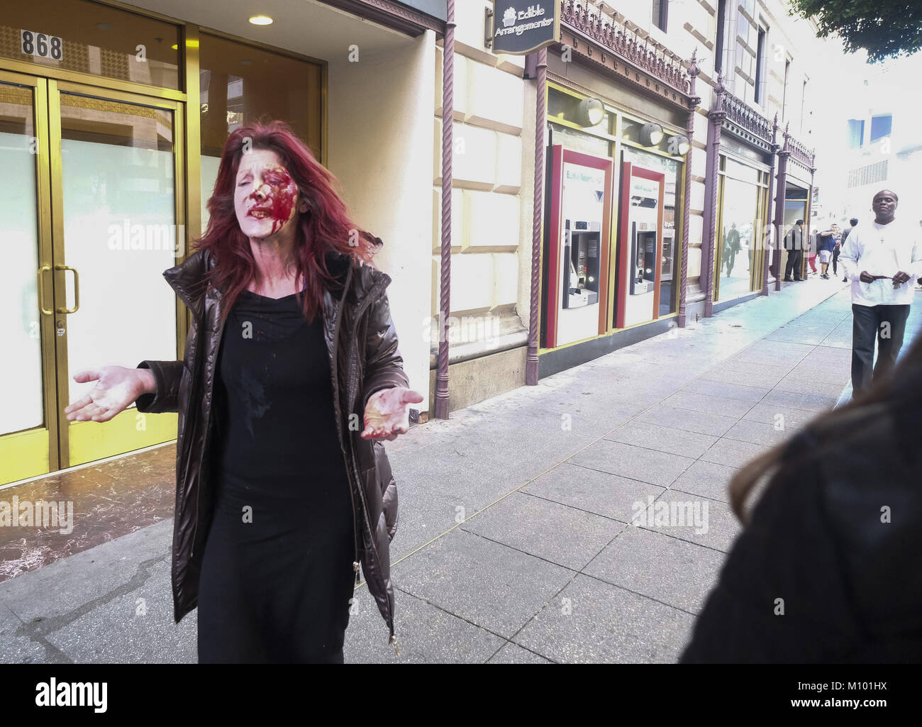 Los Angeles, California, EEUU. El 4 de enero, 2018. Una mujer rostro cubierto de sangre tras ser apuñalado un hombre (top blanco sosteniendo un en la espalda) en