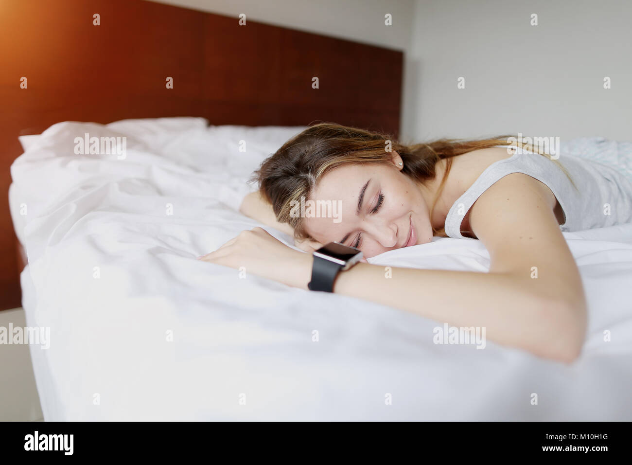 Bastante joven durmiendo utiliza Smartwatch con precisión de rastreo del sueño Foto de stock