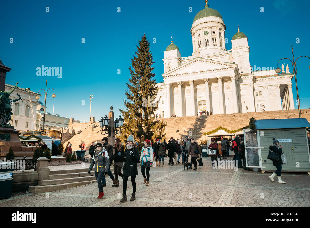Helsinki, Finlandia - 11 de diciembre de 2016: Gente caminando cerca del árbol de Navidad en la Plaza del Senado con la famosa Catedral Luterana en el soleado día de invierno Foto de stock