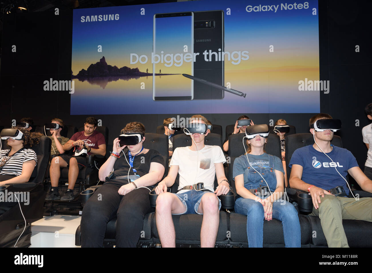 Colonia, Alemania - Agosto 24, 2017: los visitantes sentados viendo un juego por un casco de realidad virtual en el stand de Samsung en Gamescome 2017. Foto de stock