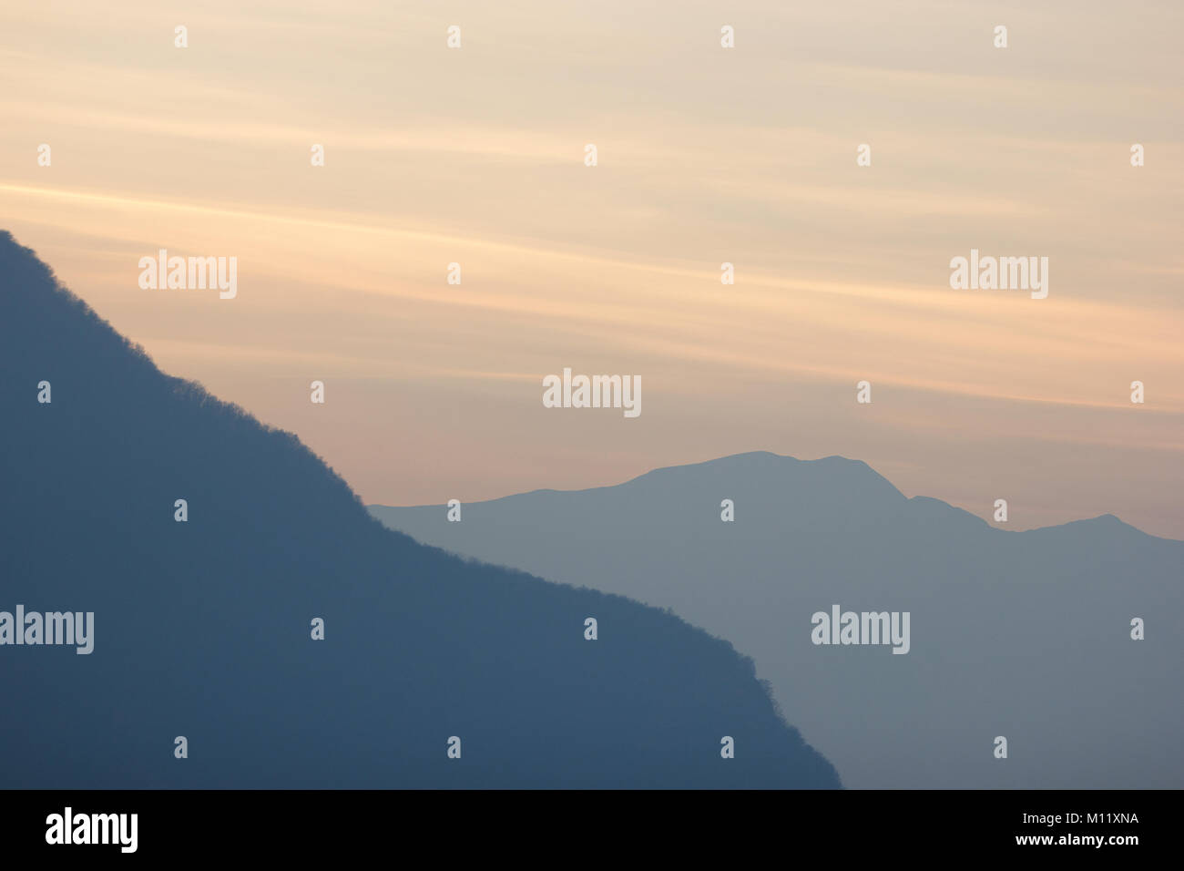 Las montañas al atardecer en el invierno en la distancia en Valtellina, Italia Foto de stock