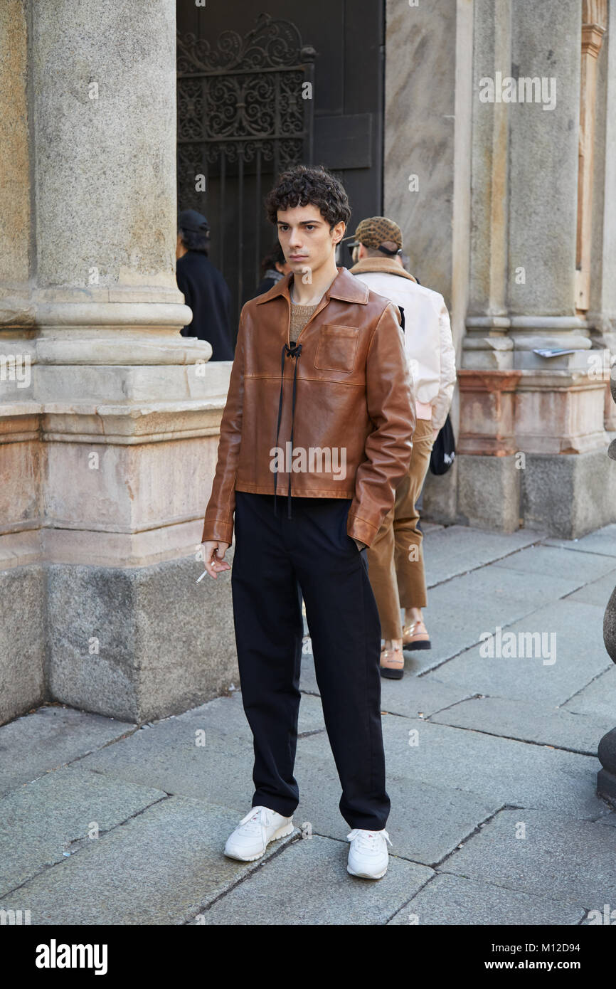 Milán - 14 de enero: hombre con chaqueta de cuero marrón y pantalón negro antes de MSGM Fashion la Semana de moda de Milán street style el 14 de