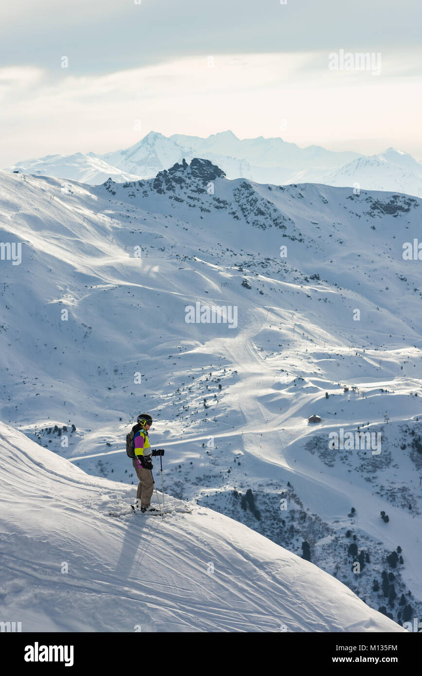 Un esquiador macho defiende y admira la vista a las montañas y la zona de esquí de los Tres Valles en la distancia, Méribel, Francia Foto de stock
