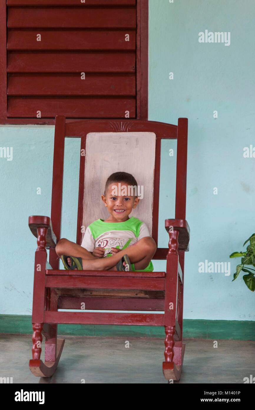 Cuba, provincia de Pinar del Río, Viñales, Valle de Viñales, el Parque Nacional de Viñales, catalogada como Patrimonio de la Humanidad por la UNESCO, el niño en una silla mecedora Foto de stock
