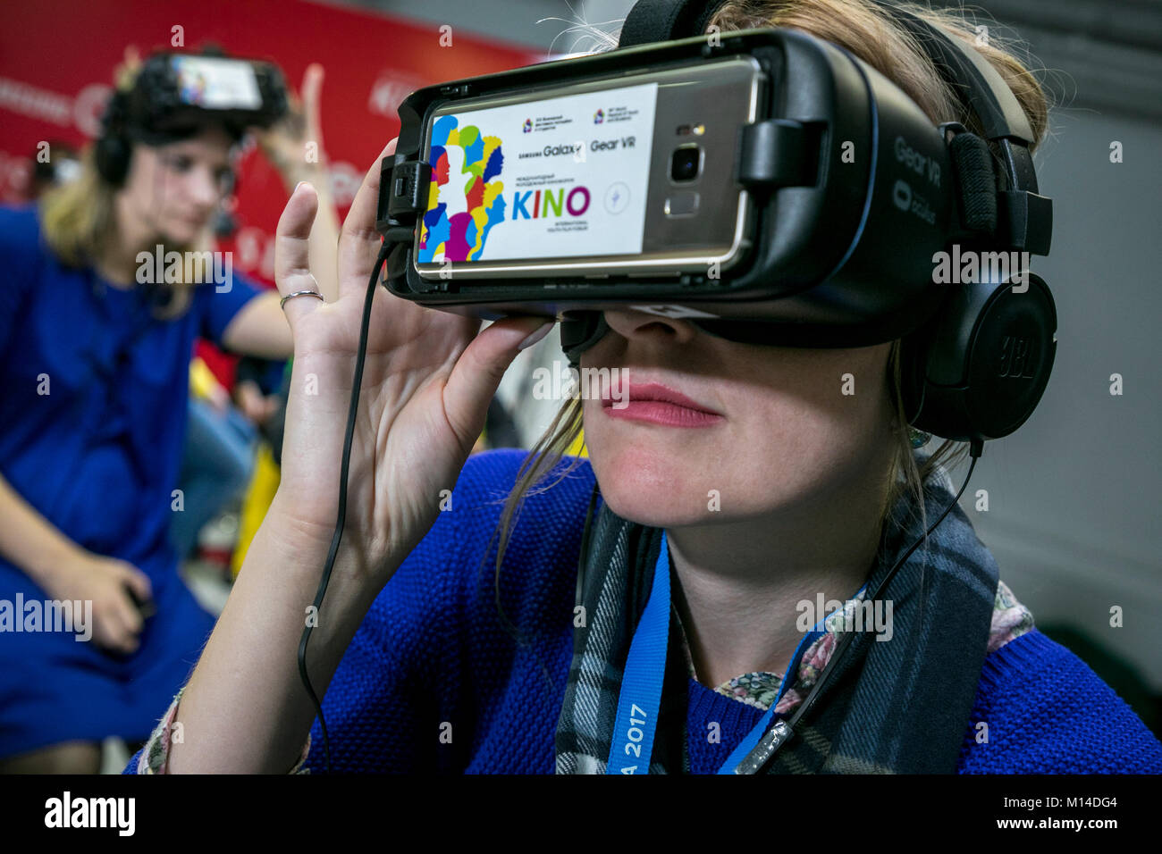 Una chica en marcha gafas VR con entusiasmo viendo una película en el auricular de la realidad virtual en el cine en la ciudad de Sochi, Rusia Foto de stock
