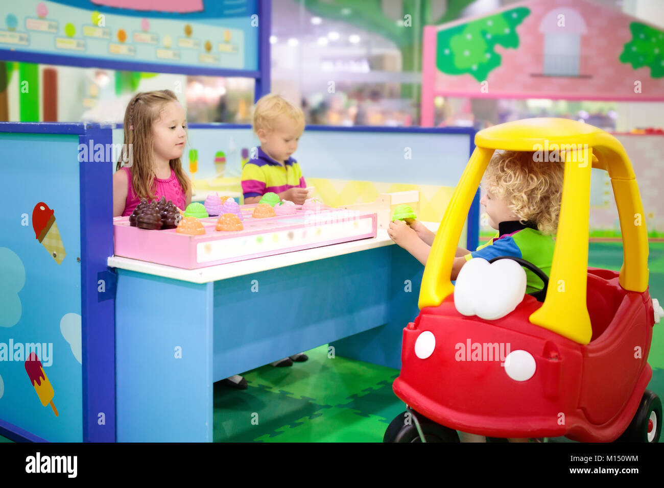 Niño jugando en la tienda de juguetes, o en el restaurante. Juguetes  educativos y juego de rol para los niños. Preescolar o kindergarten play  room. Niño en la guardería playgro kid Fotografía