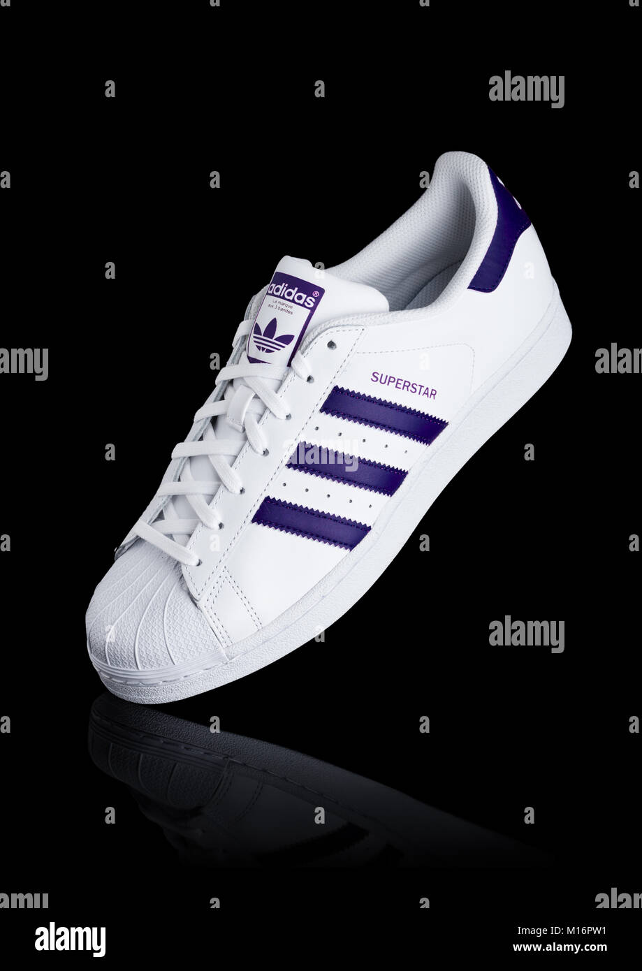 Londres, Reino Unido - 24 de enero de 2018: Originales Adidas Superstar  zapatos azul sobre fondo negro.corporación multinacional alemana que diseña  y fabrica Fotografía de stock - Alamy